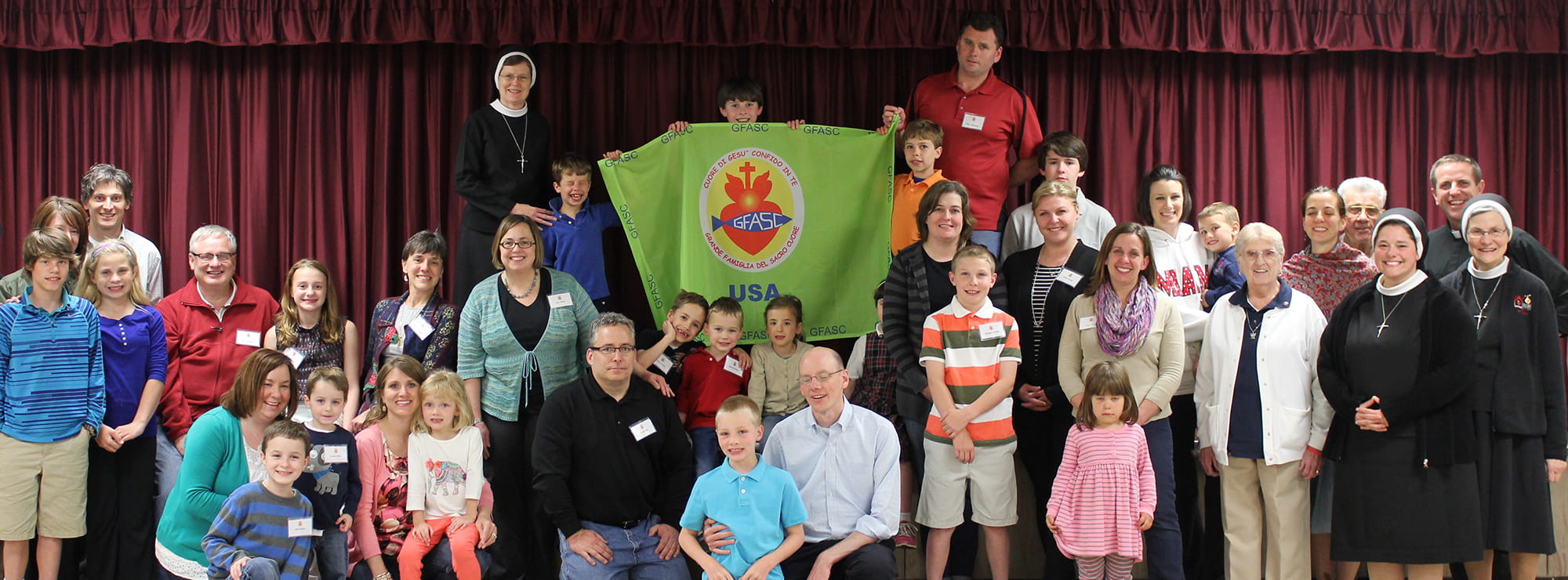 Large group of happy GFASC members holding up a GFASC banner