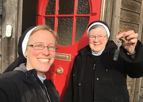 Two smiling Sisters holding keys to the new convent
