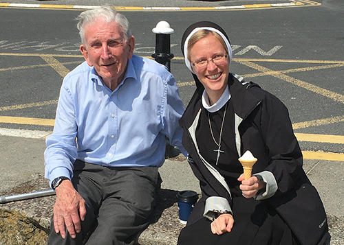 Sister holding an ice cream cone next to an older gentleman