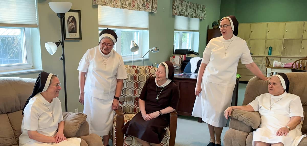 Five sisters enjoying a conversation with each other in an office