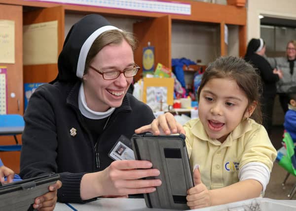A sister and a child using a tablet together