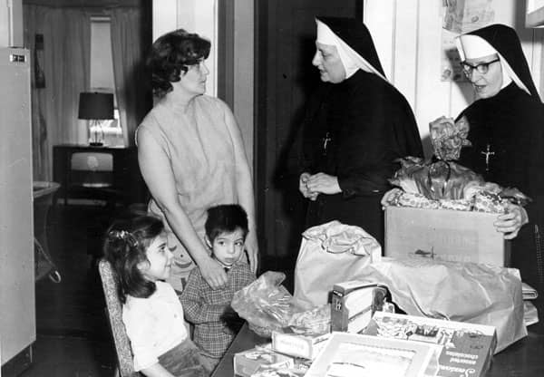 Two sisters visiting a mom and two kids in their  home