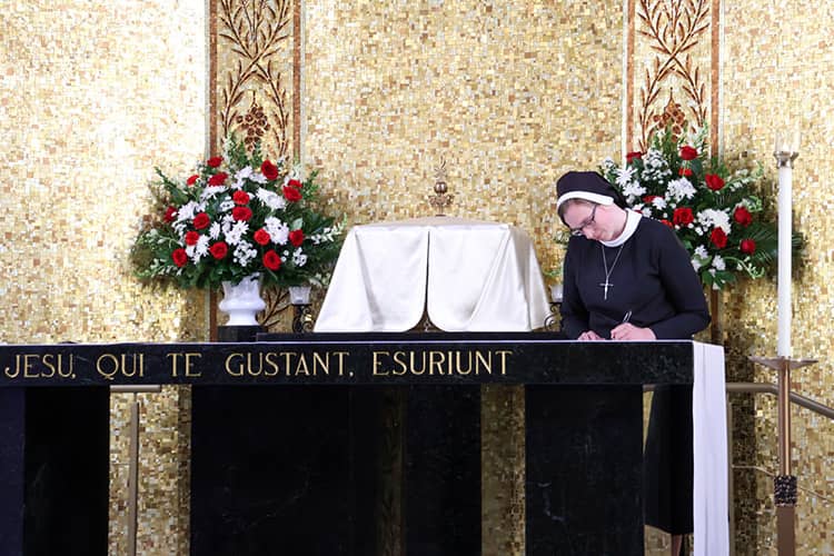 Sr. Allison Lorraine Masserano, ASCJ, signs the Formula of the Holy Vows on the altar at Mount Sacred Heart Chapel.