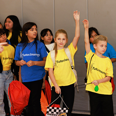 Students raising their hands during a learning event