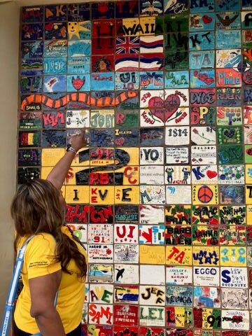 tutor pointing to colorful tiles on the wall