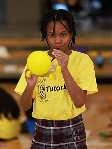 student blowing up a balloon
