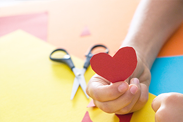 Student holding up a red paper heart