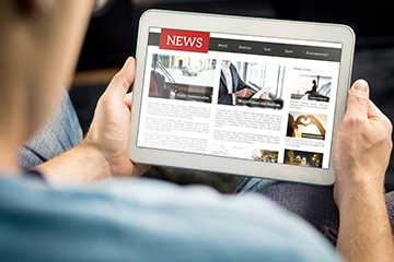 Parent reading the news online via a tablet computer