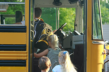 Young students getting onto a school bus