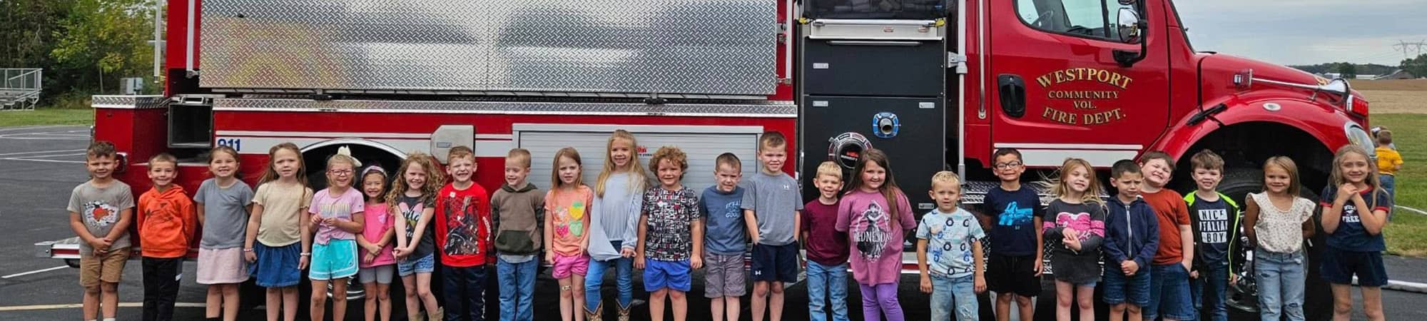 Students lined up beside a fire truck