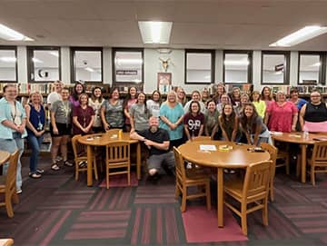group picture of adults in a room with tables