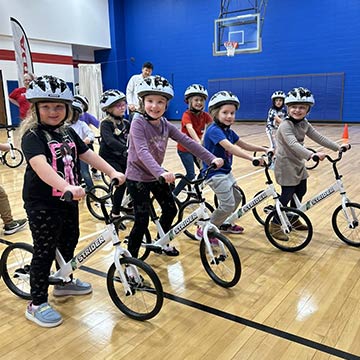 Students riding bikes in the school gym