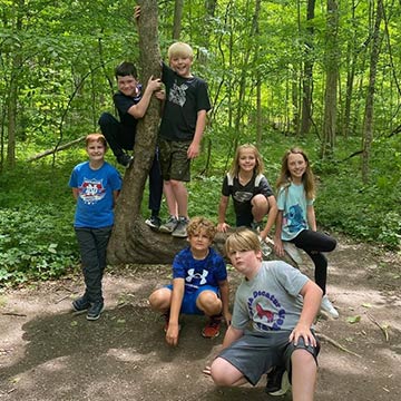 Students posing outside by a tree