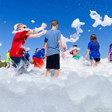 Students having fun playing with foam bubbles outside