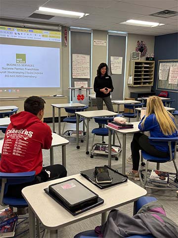 Students listening to someone give a presentation