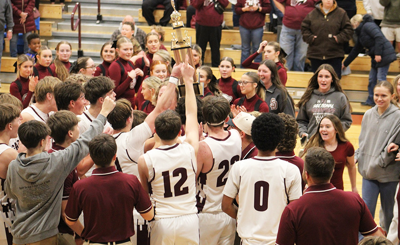 Boys basketball team celebrating on the court with fans