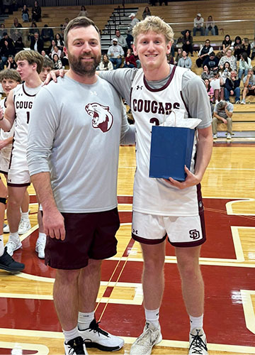 Coach with student athlete on basketball court