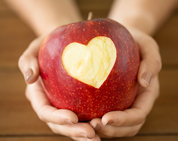 Teacher holding a red apple in her hands
