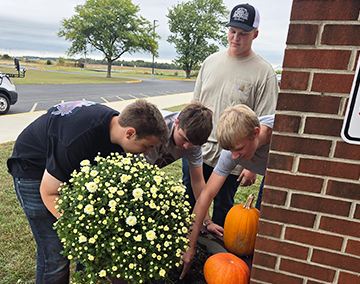 Students planting flowers outside on the school campus