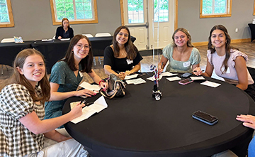 Group of happy high school girls sitting at a table