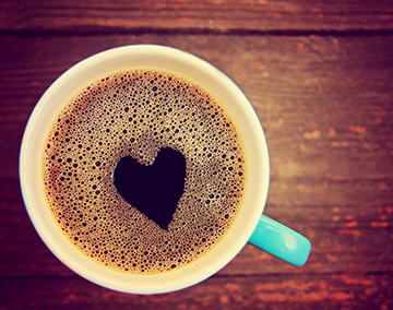 Big cup of coffee with a heart shape in the foam