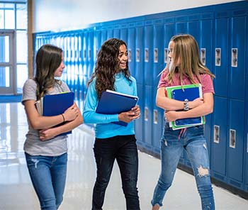 Three students walking through a hallway