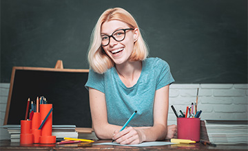 Happy teacher sitting at her desk