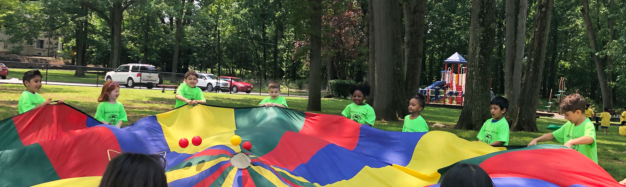 Happy students enjoying a fun parachute activity outside