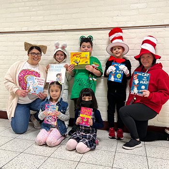 Notebook on desk in the classroom Students and staff holding up some favorite books with matching costumes