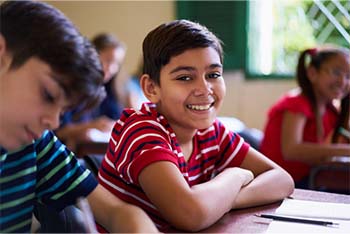 Student at a desk smiling