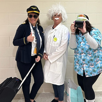 Three adults dressed as a scientist, and airline pilot, and a tourist