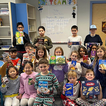 students holding up boxes of food