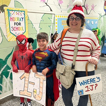 An adult and students in holiday costume