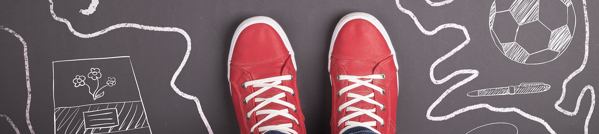 Red sneakers on top of a chalk drawing