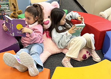 Two girls reading books in the library