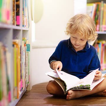 Boy reading a book in the library