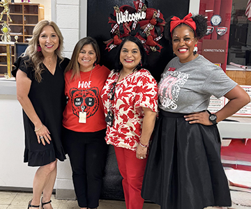 Four festive women dressed in black and red
