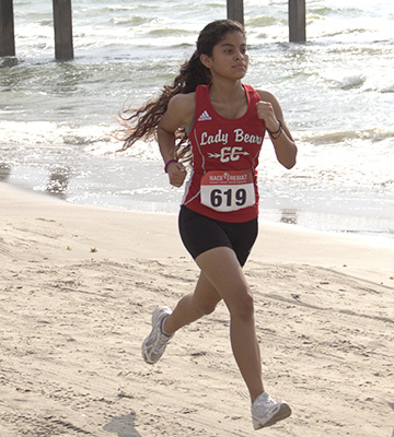 Female cross country runner running on the beach
