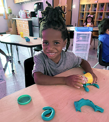 Child smiling from craft table
