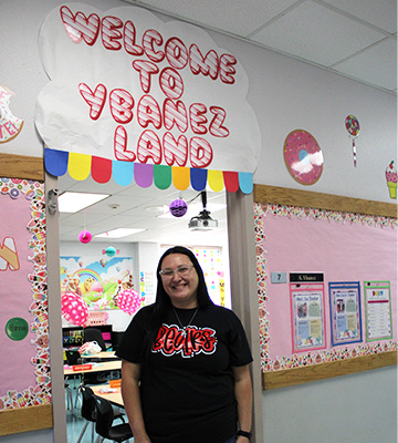 Teacher smiling outside her classroom door