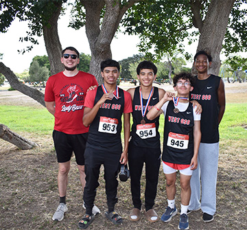 Cross country runners with coaches at a meet