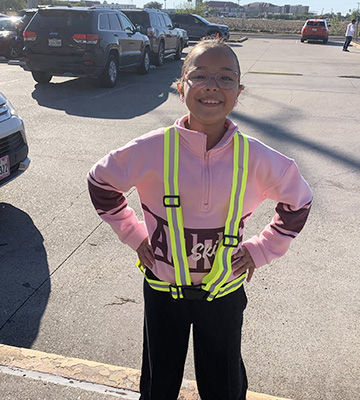 Happy student outside wearing a safety vest