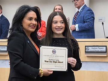 Student and mayor holding an award