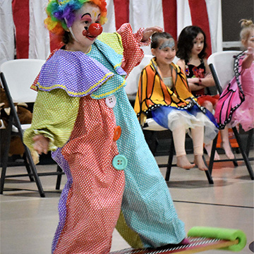 Students dressed as a clown on a balance board