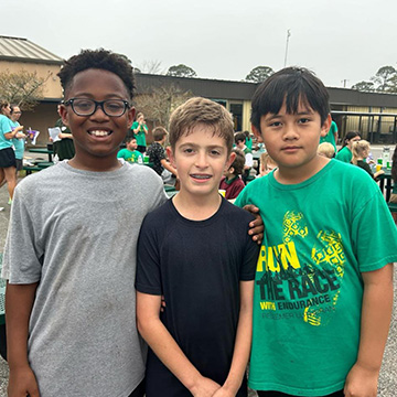 three students standing together outside