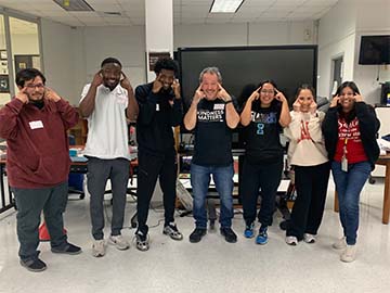 Staff and students pointing to their brain