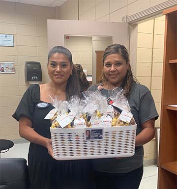 Staff member and realtor holding a basket