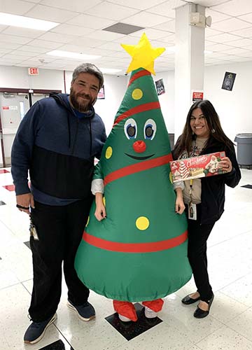 Two staff members with a blow up Christmas tree