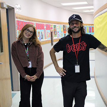 Two staff members standing in the hallway