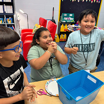 smiling students working on a project together